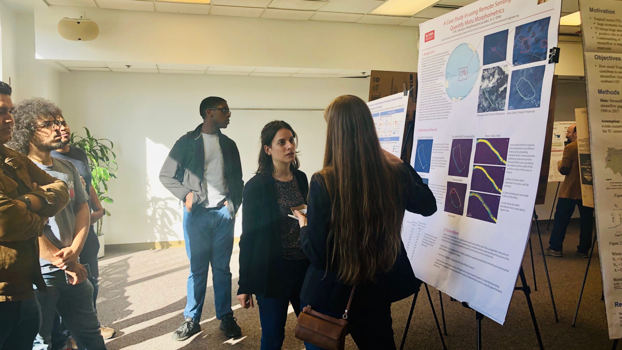 Students discuss a research poster at the RISING Poster Session.