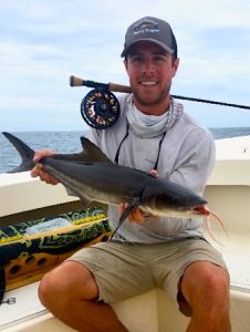 Riley Gallagher photographed on a boat with a cobia fish.