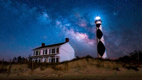Lighthouse & building under stars