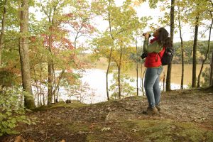 Woman near lake with binoculars